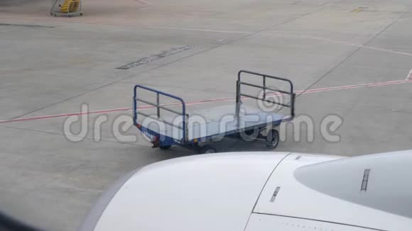 机场的空行李车从窗口看到的平面视频的预览图