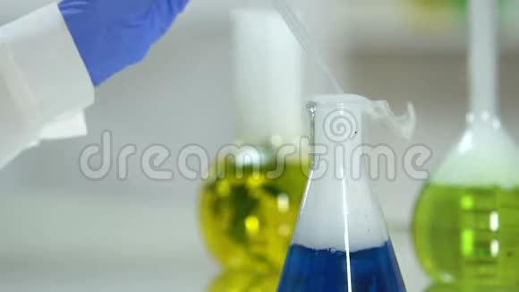 科学家从烧瓶中提取蓝色液体样品进行研究视频的预览图