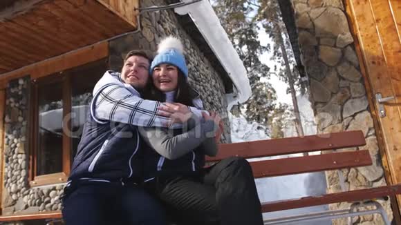 幸福相爱的一对夫妇坐在山里的冬夏莱特附近的长凳上视频的预览图