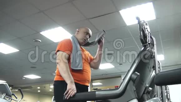一个胖子在跑步机上行走然后离开视频的预览图