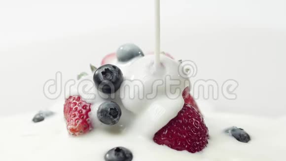 新鲜健康食品草莓和蓝莓倒入酸奶酸奶和鲜奶油中的浆果视频的预览图