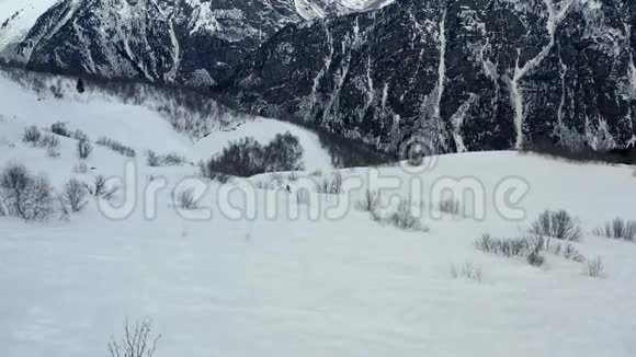 一个人在山下的滑雪板上自由活动背景上令人叹为观止的山视频的预览图