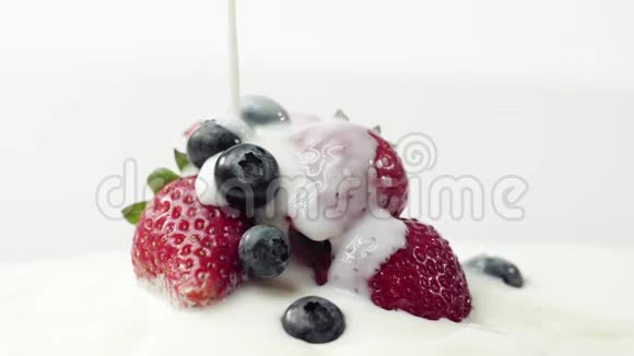新鲜健康食品草莓和蓝莓倒入酸奶酸奶和鲜奶油中的浆果新鲜水果视频的预览图