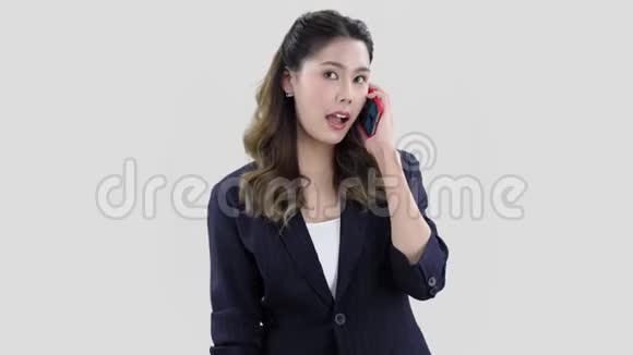 穿着深蓝色夹克的快乐亚洲模特微笑的女孩在电话里交谈视频的预览图