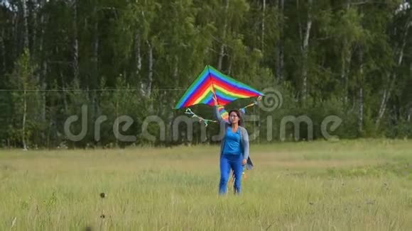 户外有彩虹风筝的女人视频的预览图