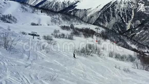 一个人在滑雪电梯附近的滑雪板上自由活动空中拍摄的画面是4k视频的预览图