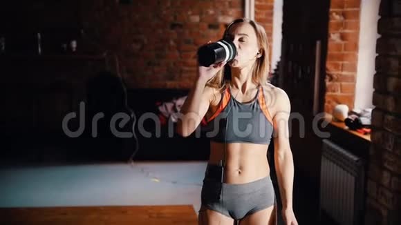 一位女运动员在健身房训练后喝水视频的预览图