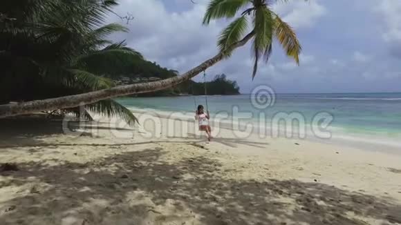 塞舌尔巴伊拉扎雷海滩棕榈树上的女孩秋千视频的预览图