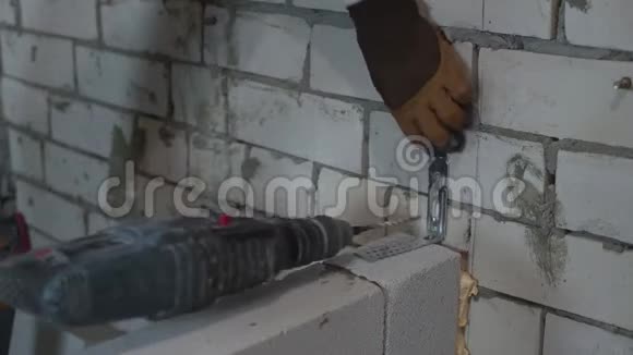 建筑工人用电钻在砖墙上打螺纹孔连接夹具视频的预览图