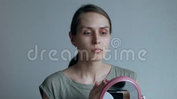 女人把奶油粉底涂在脸上女性在家的平凡日子视频的预览图