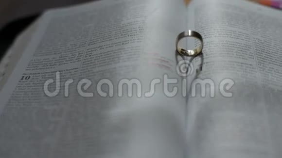 开放圣经中形成心形的结婚戒指视频的预览图