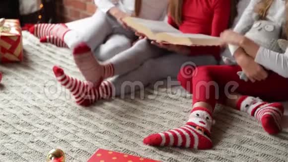 三姐妹穿着柔软的睡衣坐在床上三胞胎的女孩读了一本圣诞故事书卧室被装饰视频的预览图