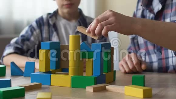 父子俩玩玩具方块盖小房子一起玩得很开心视频的预览图