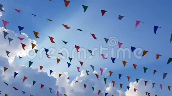 4K色彩斑斓的设计装饰三角彩旗迎风飘扬挂在蓝天背景上为欢乐的节日聚会而设视频的预览图