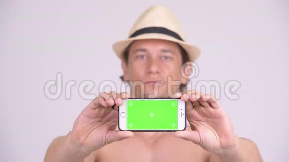 一个肌肉发达的快乐游客的脸展示电话赤膊视频的预览图