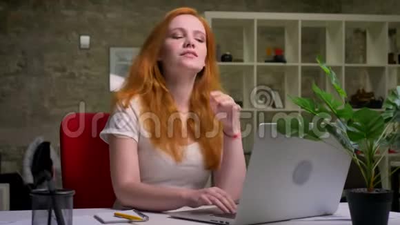 佩蒂微笑着的白种人生姜女商人正在愉快地看着笔记本电脑屏幕手牵着她的头视频的预览图