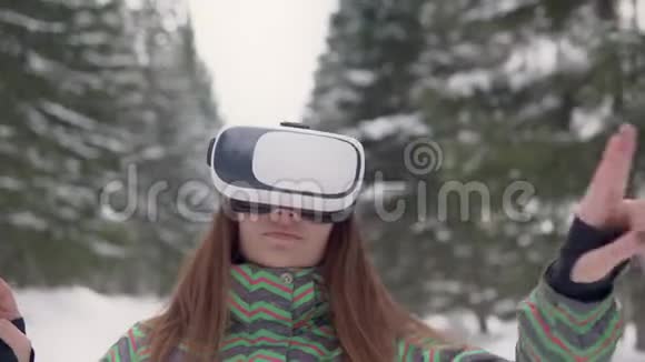 一个年轻的女人在森林里的街道上使用电子虚拟现实眼镜4K视频的预览图