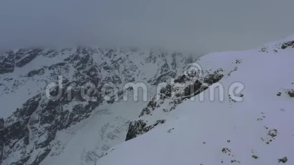 在暴风雪期间山上有美丽的鸟瞰图顶部有雾4k视频的预览图