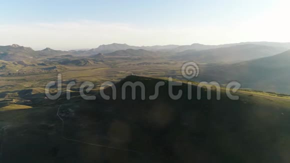 高青山顶乡村道路的鸟瞰图背景是蓝色的草地和山脉视频的预览图