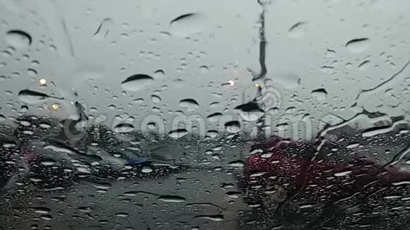 雨滴沿着挡风玻璃流下从车里看街上跑着一个湿漉漉的人视频的预览图