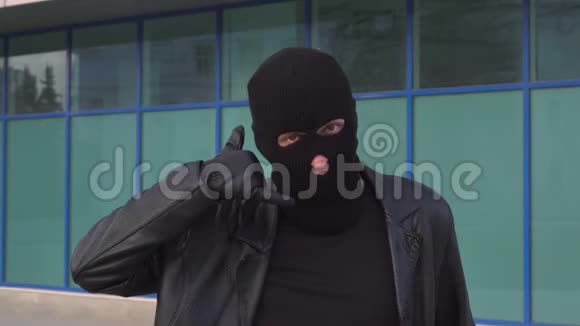 罪犯小偷或戴面具的强盗用手指做手势视频的预览图