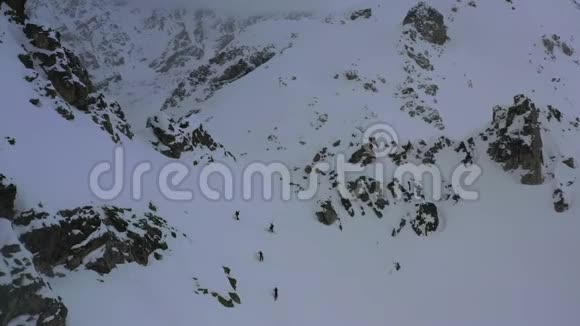 在暴风雪中群山覆盖着雾和雪人们爬上滑雪板4K视频的预览图