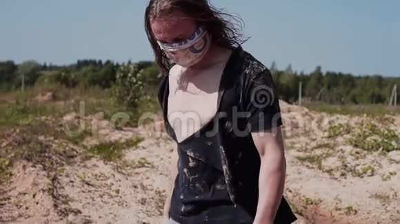 一个穿着脏衣服的流浪汉在沙漠里走着嘴上绑着绷带视频的预览图