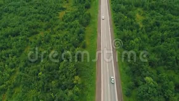 从空中俯瞰田野之间的道路夏天的颜色绿色乡村和汽车的空中行驶4K视频的预览图