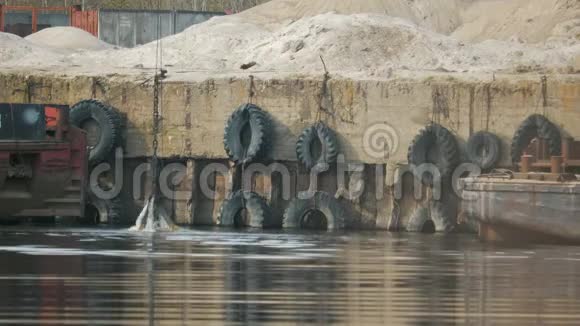 挖掘机的抓斗从河中升起在港口的背景下溅起水花视频的预览图