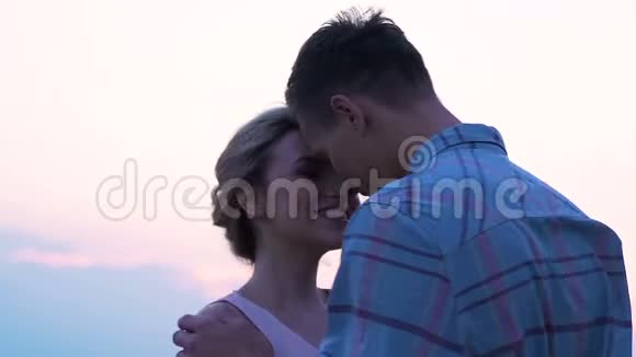年轻人和女人一起享受时光亲吻日落蜜月联系视频的预览图
