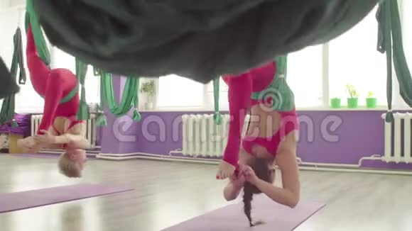 反重力瑜伽两个漂亮的女人在吊床上做运动视频的预览图