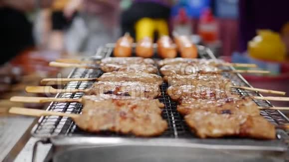男人在烤架上烤沙第马来西亚印度尼西亚和泰国的流行食品街头美食4k视频的预览图