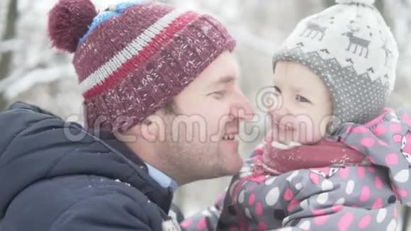 爸爸和他的小女儿在冬天的公园散步视频的预览图