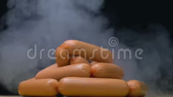 生的冷冻香肠在盘子里旋转慢慢地被烟雾吹着视频的预览图
