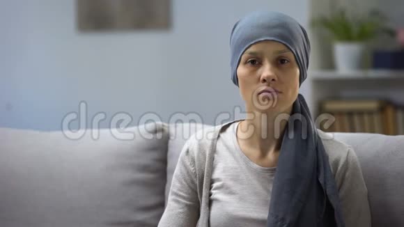 化疗后的女人坐在家里看镜头背景视频的预览图