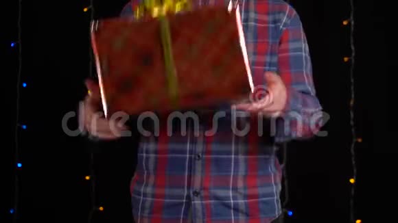 带黑背景礼盒的男孩新年快乐圣诞快乐情人节礼品盒视频的预览图