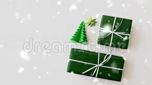 在礼品盒和圣诞树折纸上下雪视频的预览图
