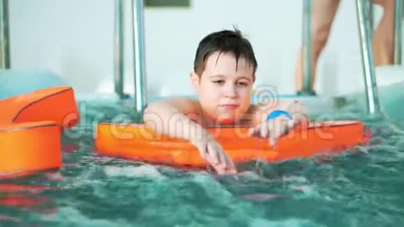 快乐的小男孩在按摩浴缸里的摄像机上游泳视频的预览图