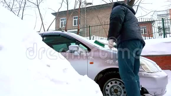人用刷子在客厅区清理汽车上的雪视频的预览图