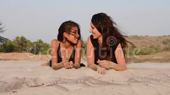 妈妈和十几岁的女儿一起躺在沙滩上谈笑风生视频的预览图