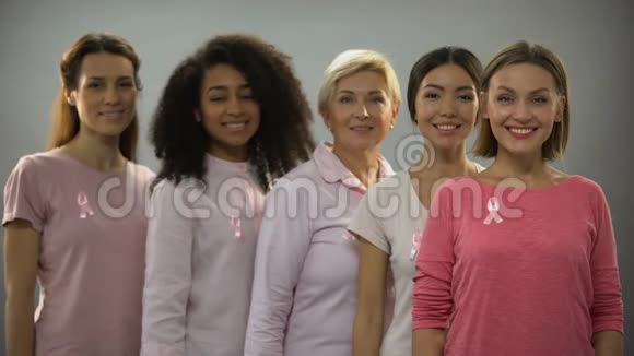 穿粉色衣服和缎带的微笑妇女乳腺癌意识标志视频的预览图