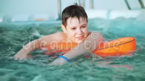 快乐的小男孩在按摩浴缸里的摄像机上游泳视频的预览图
