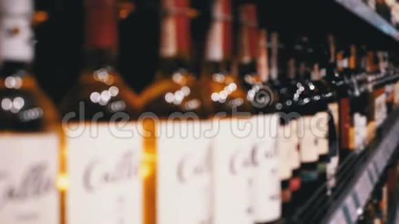布卢尔商店橱窗上装有价格标签的瓶装葡萄酒的架子和架子超市卖酒视频的预览图