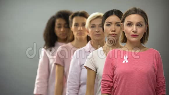 穿着粉红色乳腺癌意识丝带的严肃妇女排着队视频的预览图