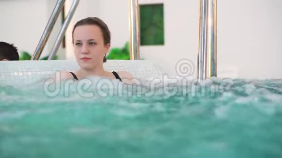 按摩浴缸里的年轻女孩公共水上乐园里的水疗程序视频的预览图