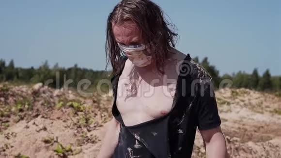 一个穿着脏衣服的流浪汉在沙漠里走着嘴上绑着绷带视频的预览图