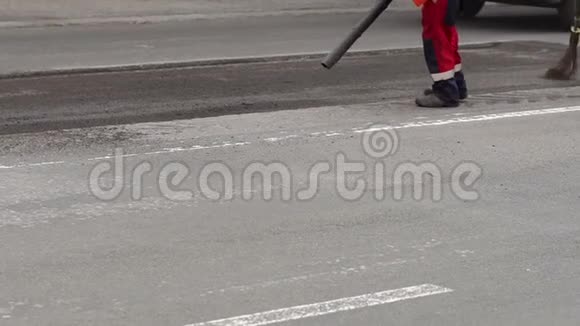 工人用一个大鼓风机从道路上吹出碎片和石头新沥青视频的预览图