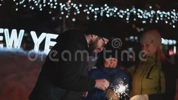 家人庆祝新年父亲点亮孟加拉灯在街上的夜晚冬天视频的预览图