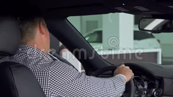 一个英俊的男人微笑着站在肩膀上竖起大拇指坐在新车里视频的预览图