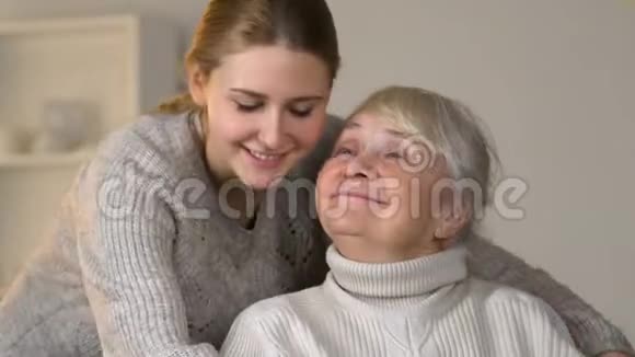 有爱心的孙女抱着轮椅上的残疾幸福女子家庭价值观视频的预览图